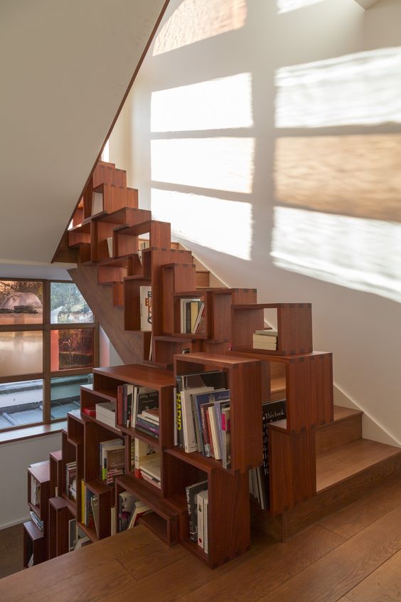 la ringhiera della scala realizzata con una sistemazione in legno tipo libreria